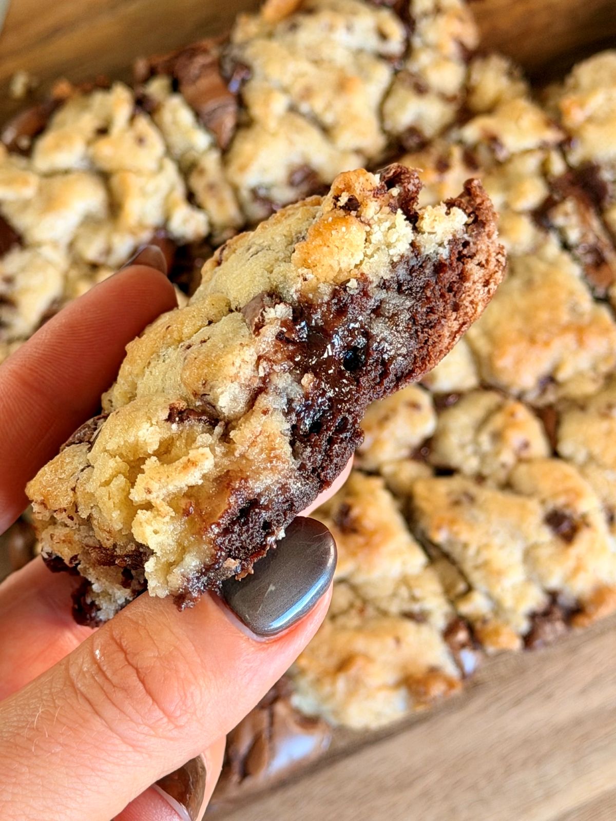 Part de brookie dans la main, avec le brownie fondant et le cookie croustillant