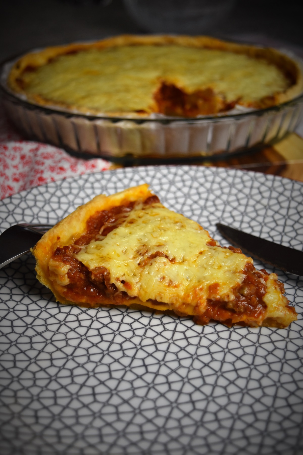 part de tarte à la tomate, viande hachée et fromages