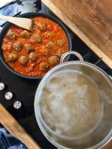 Cuisson des spaghetti et boulettes de boeuf à la sauce tomate