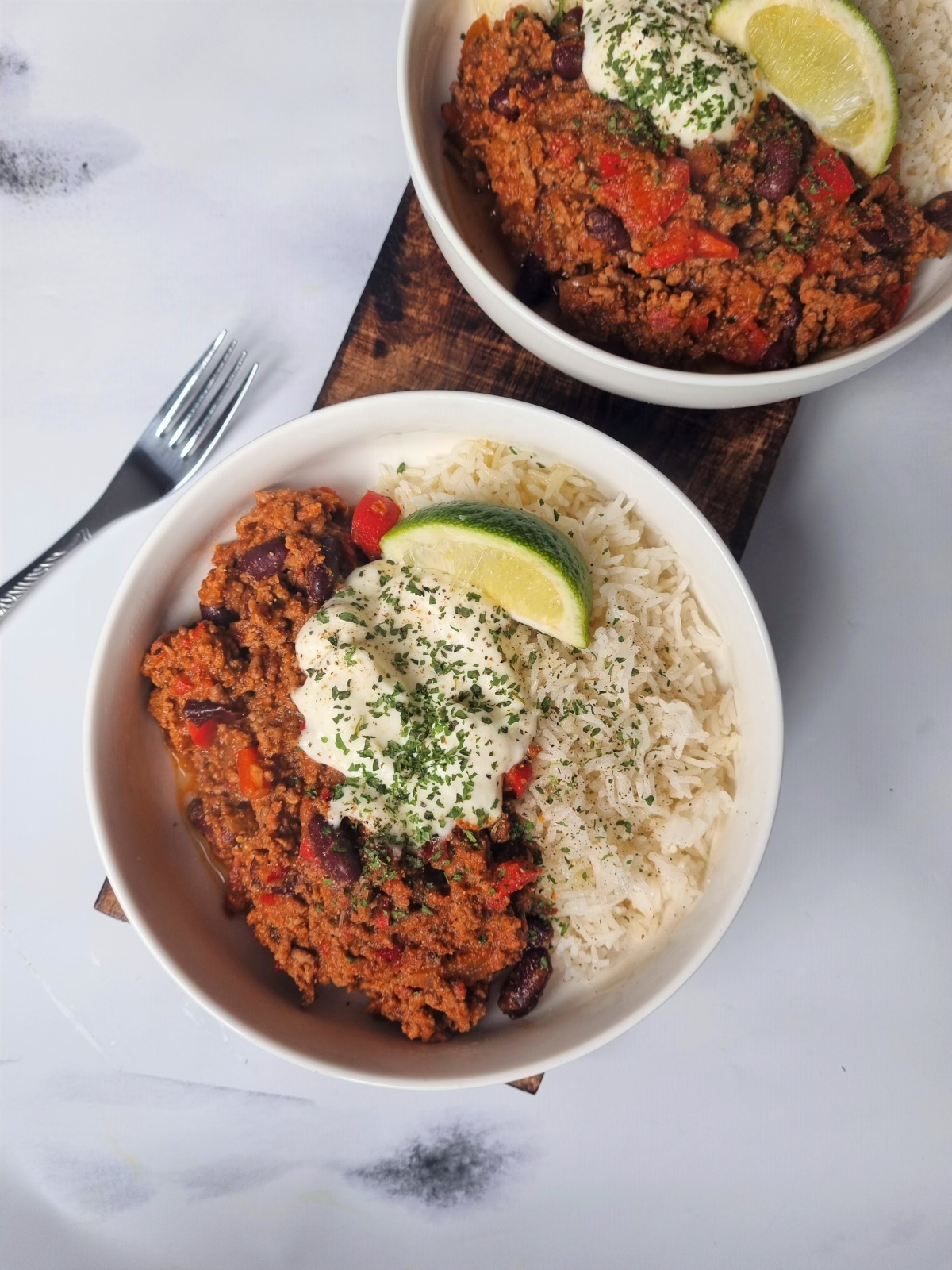 Chili con carne, riz basmati, crème, citron vert