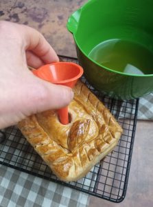 Verser la gelée du pâté avec un entonnoir