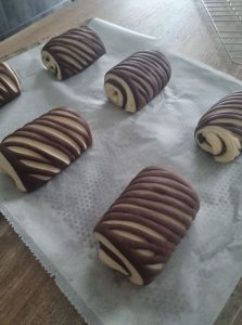 Pains au chocolat maison sur papier cuisson et grille perforée