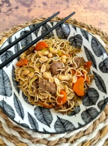 Wok de nouilles au boeuf, légumes, cacahuètes