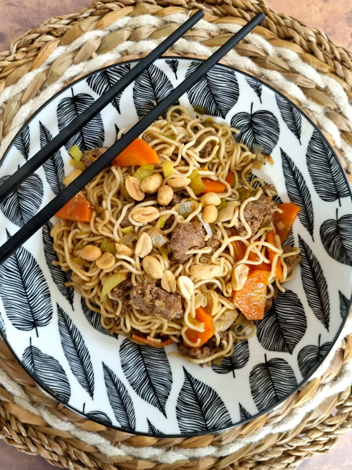 Wok de nouilles, boeuf haché, légumes sautés et cacahuètes