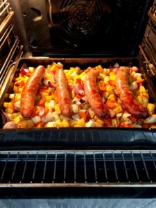 Saucisses et légumes au four