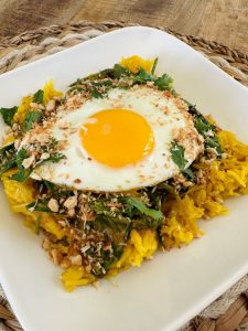 Riz curcuma, curry d'épinards, noix de cajou, noix de coco et oeuf au plat