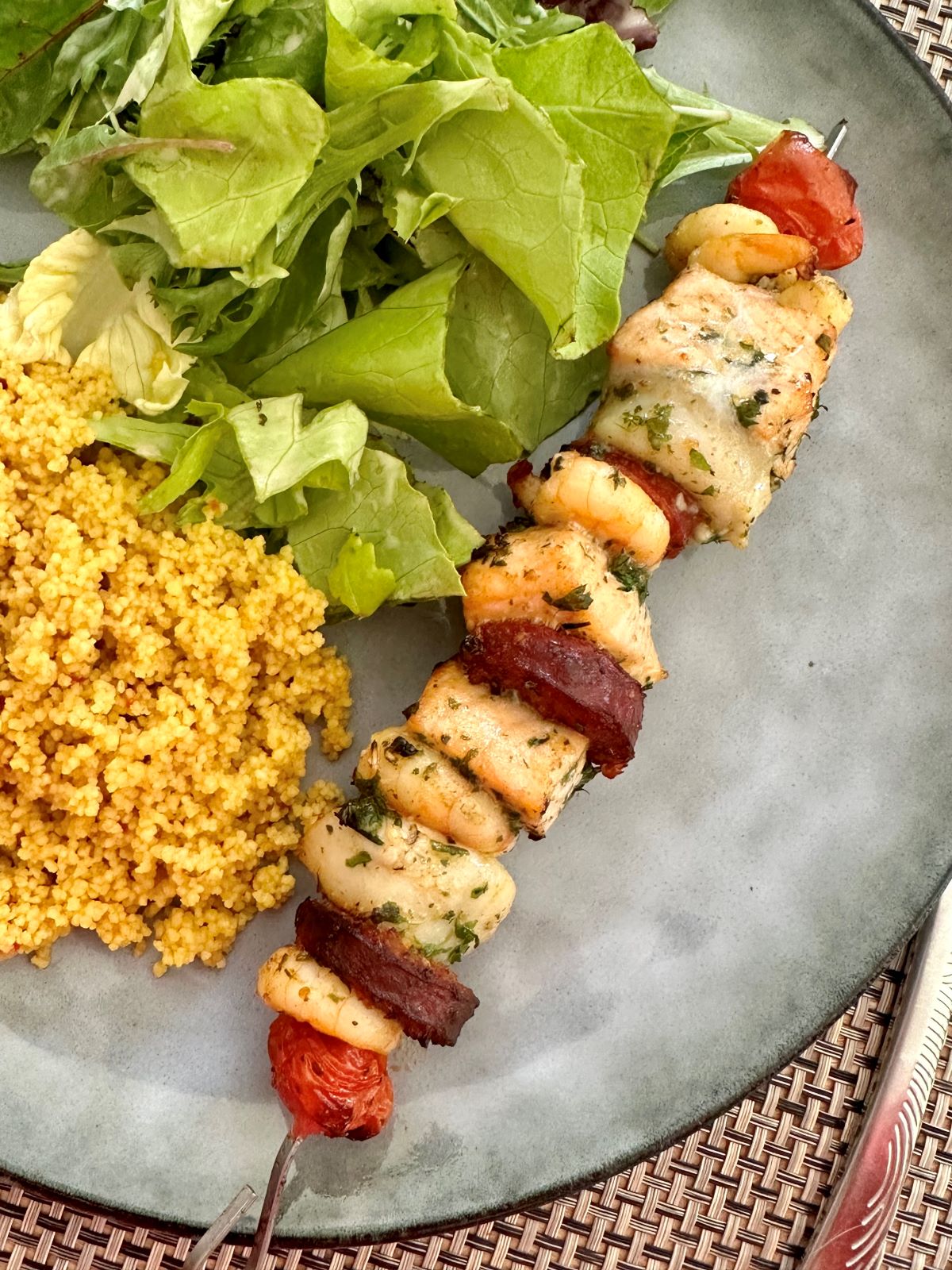 Brochette de saumon, crevettes, saint-jacques et chorizo avec couscous épicé et salade