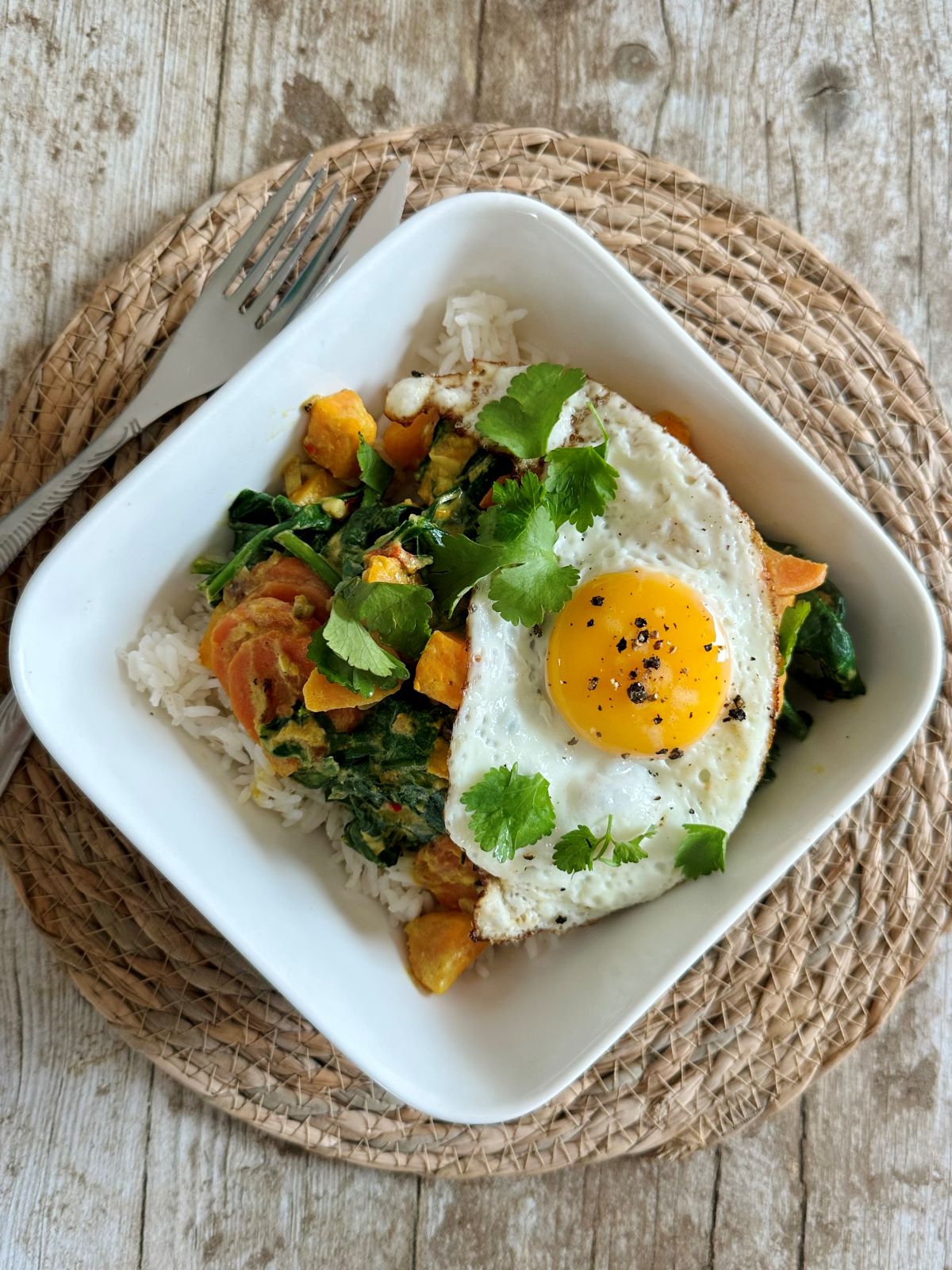 Curry végétarien indien à la patate douce et épinards avec un oeuf au plat