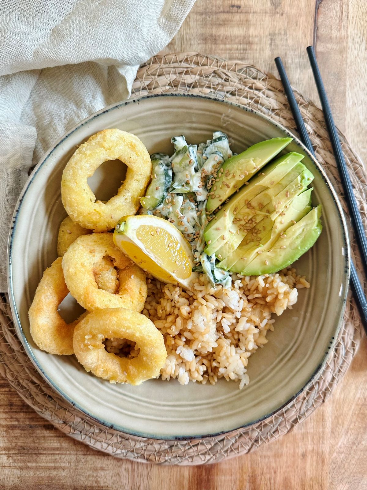 Bowl avec calamars à la romaine, riz, salade de concombre, avocat