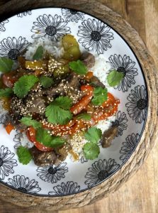 Bowl asiatique de boeuf et légumes sautés avec riz, sésame, coriandre