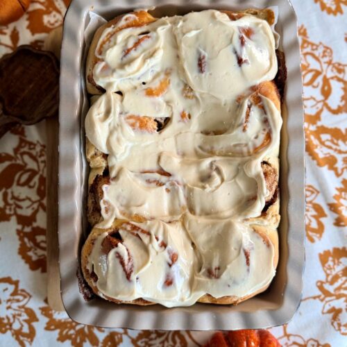 Cinnamon rolls maison nappés de glaçage au cream cheese dans un plat de cuisson