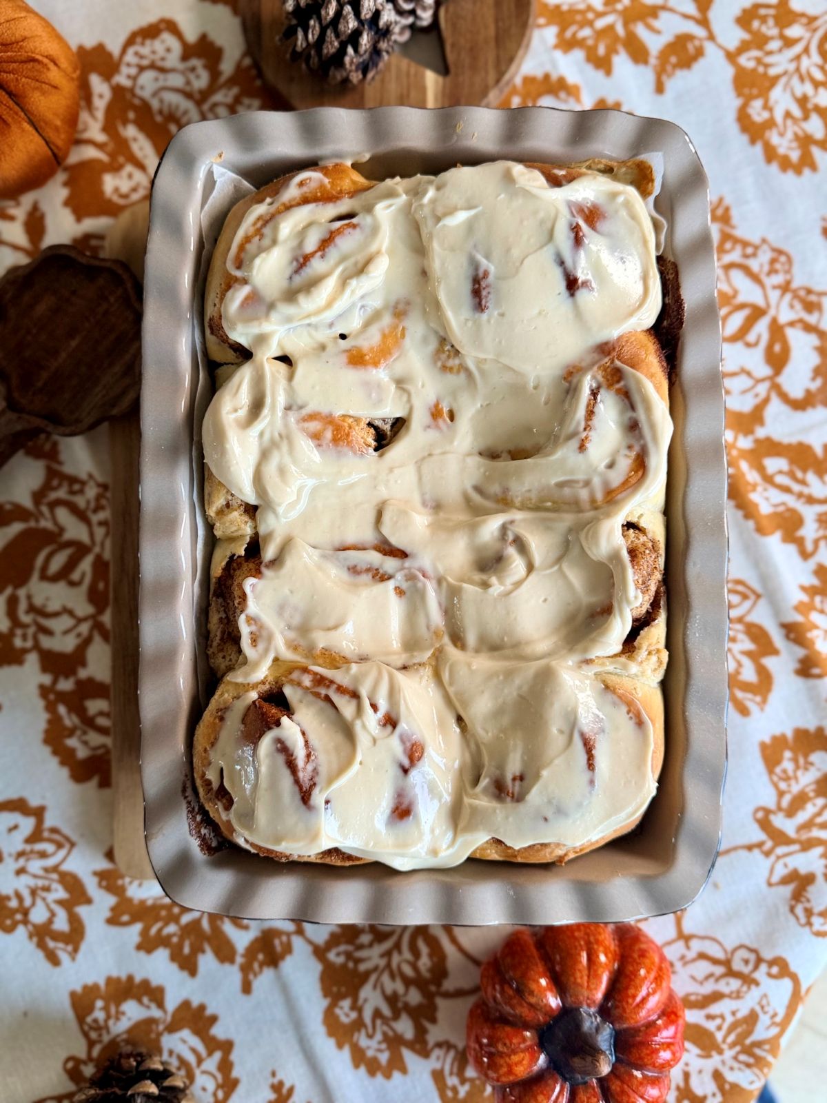 Cinnamon rolls maison nappés de glaçage au cream cheese dans un plat de cuisson