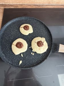 Déposer du nutella au centre du pancake en cuisson