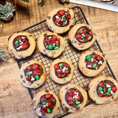 Cookies décorés façon Noël, aux pépites de chocolat, avec un nappage chocolat au lait et des décorations de noël