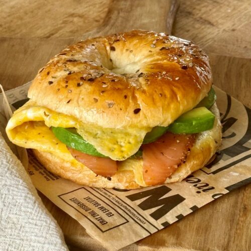 Bagel avec omelette, saumon fumé, lamelles d'avocat et pesto à la coriandre