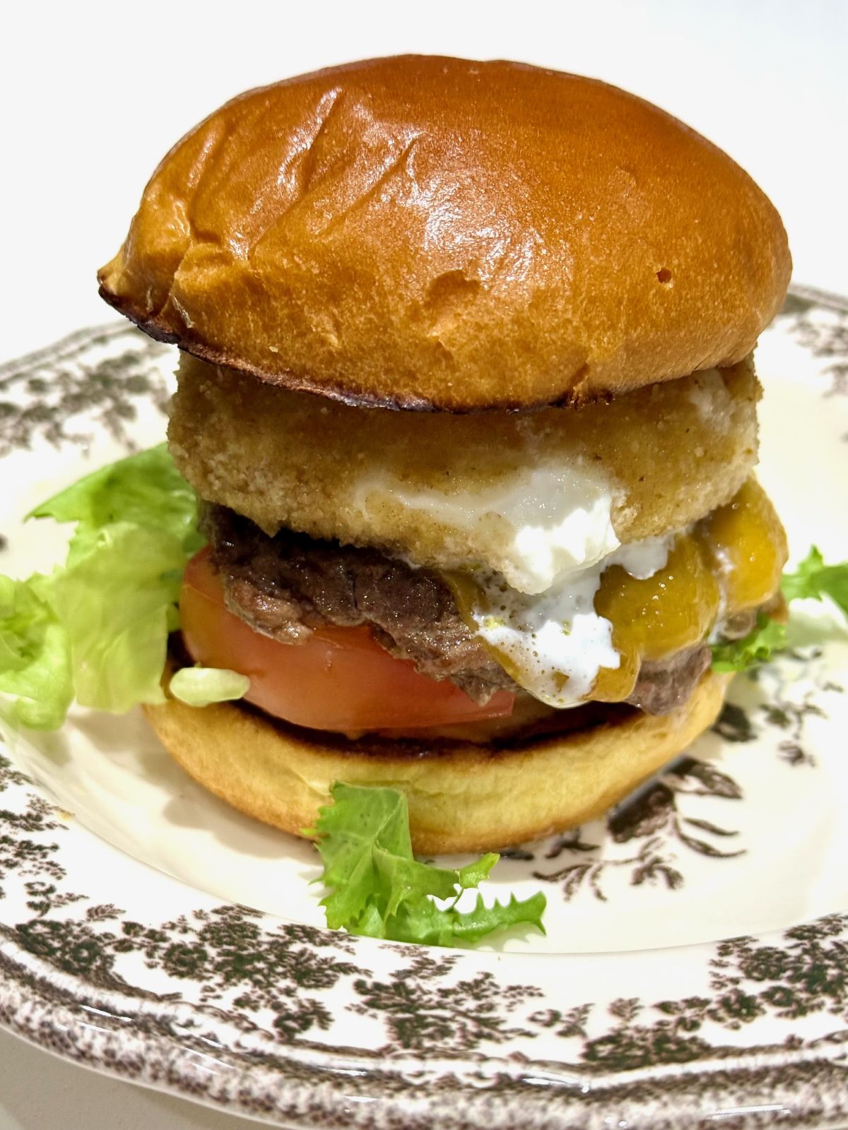 hamburger steak smashé, bun brioché, burrata panée, salade, tomate, cheddar et mayonnaise pimentée