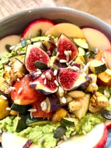 Légumes rôtis sur une crème d'avocat, avec par-dessus un figue rôtie et d ela pomme crue