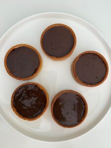 ganache chocolat sur fond de tartelettes au caramel et cacahuètes