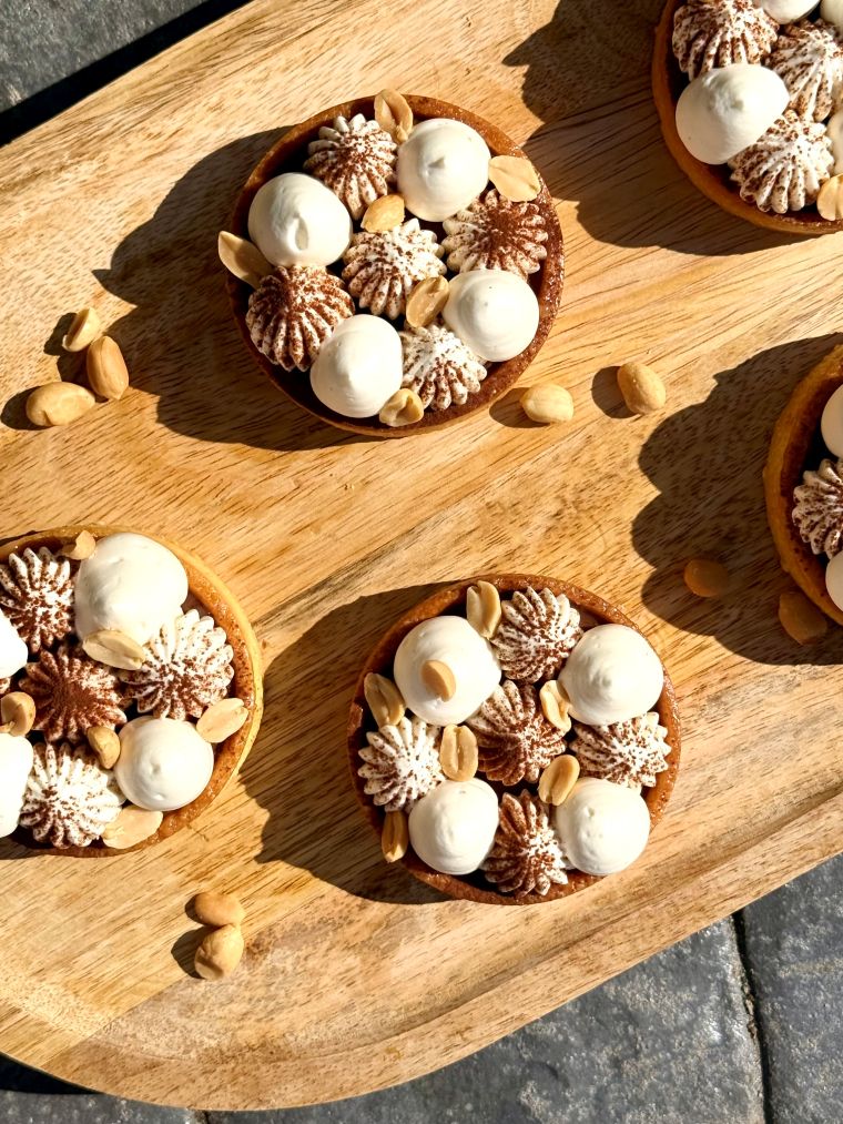 Tartelettes façon Snickers au caramel beurre salé et cacahuètes sur une assiette