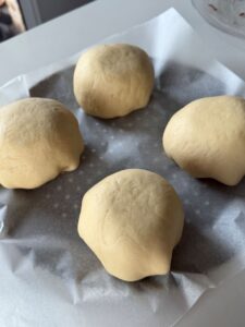 Buns burgers façonnés, sur une plauqe de cuisson avant d'être enfournés