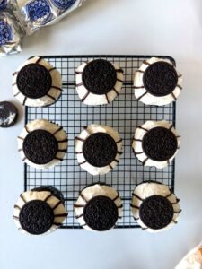 Grille avec 9 cupcakes au glaçage cream cheese et un demi_Oreo dessus