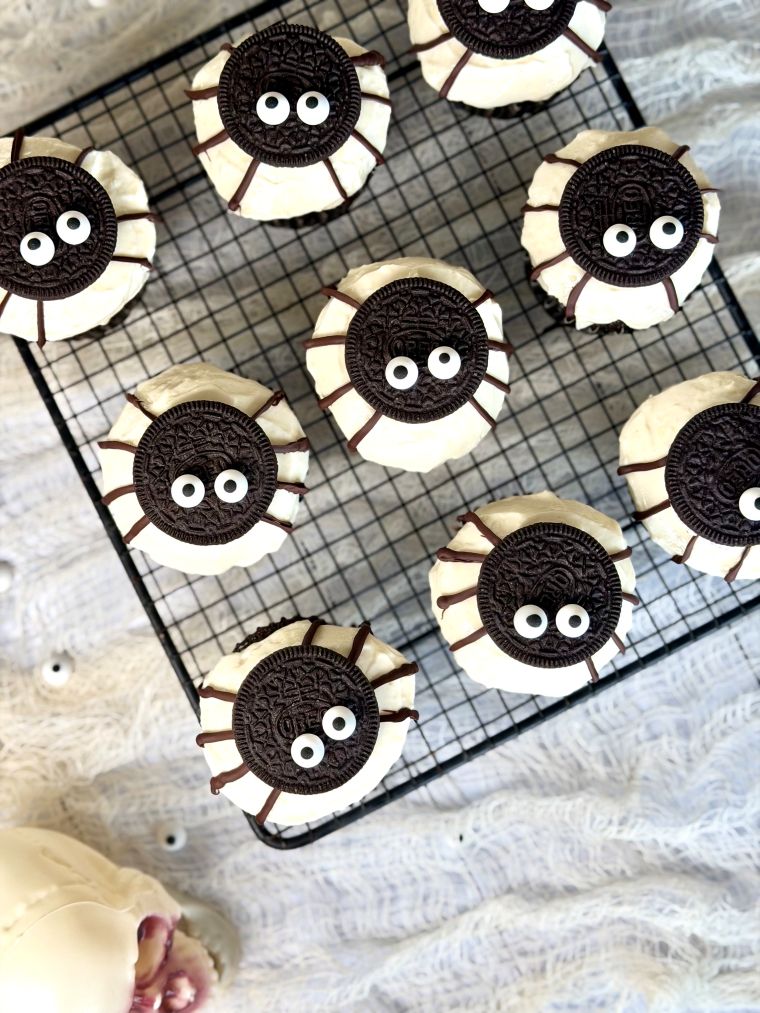 9 cupcakes araignées Oreo, avec une base cacao, un glaçage cream cheese, 1/2 Oreo, des pattes au chocolat et des yeux comestibles