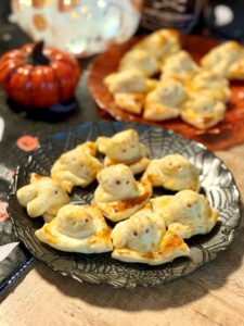 Petits feuilletés saucisses pour Halloween en forme de fantôme, sur la table d'Halloween